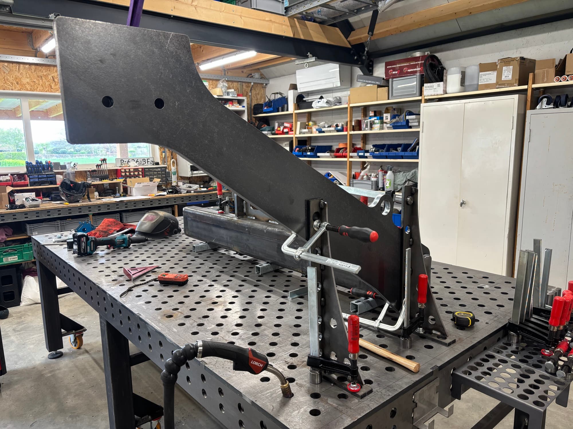 Zwarte machine-arm, opgespannen op de lastafel in de werkplaats van WTTec